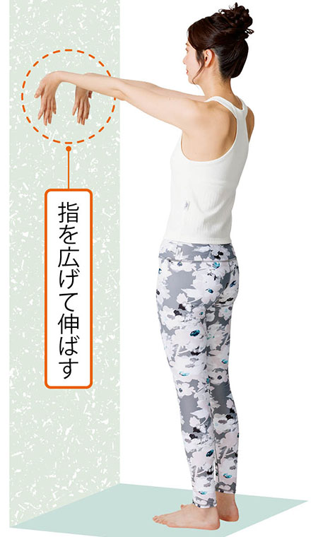 壁に手をついてひじを伸ばす女性