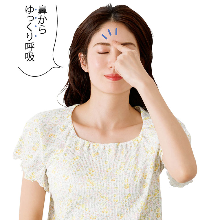 眉間を触る女性