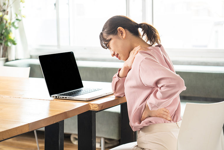 肩こり、腰痛に悩む女性