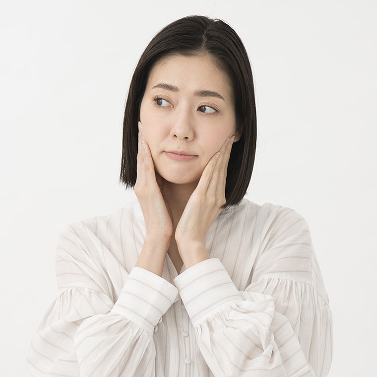 頬に手をあてる女性