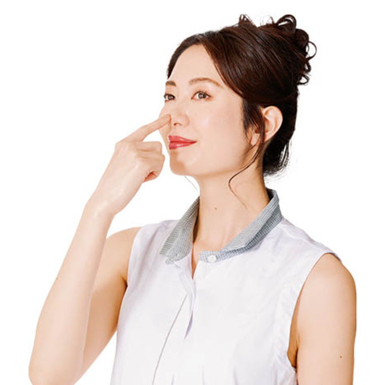 指先を鼻にあてる女性