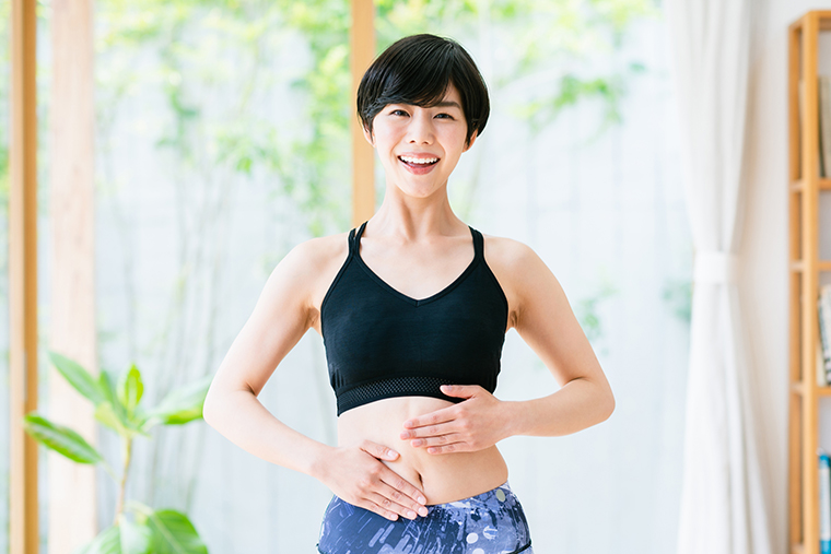お腹に手をあてる女性
