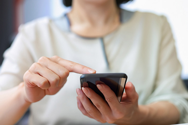 スマホを使う女性の手元
