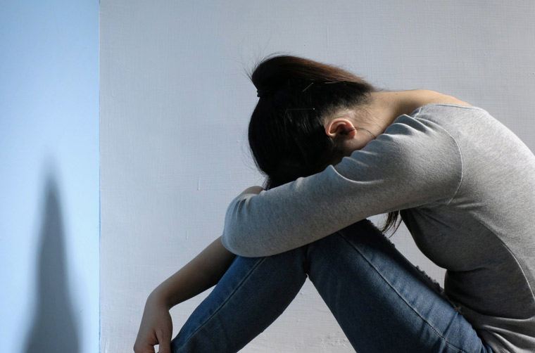 壁の前で落ち込む女性