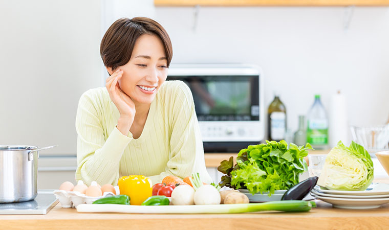 様々な食材を笑顔で眺める女性