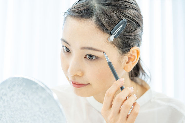 眉毛を描いている女性