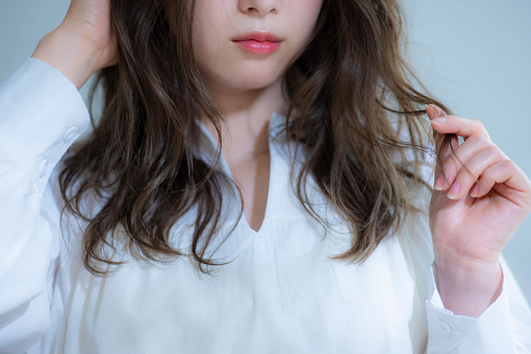 髪の毛を触る女性