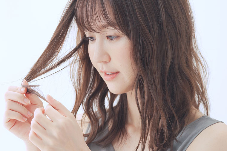 オリーブベージュ_髪色を確認する女性
