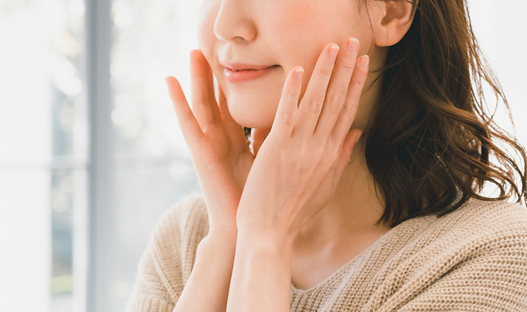 頬に手をあてる女性の口元