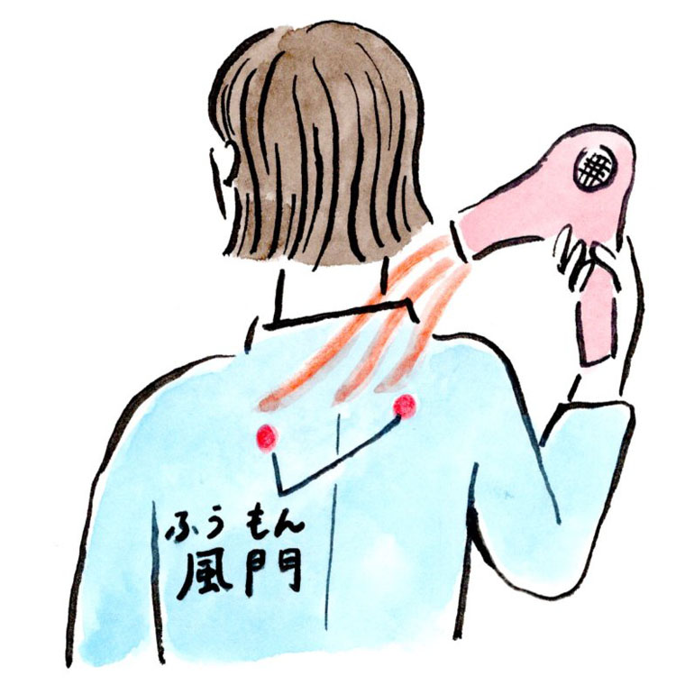 風門のツボにドライヤーを当てている女性