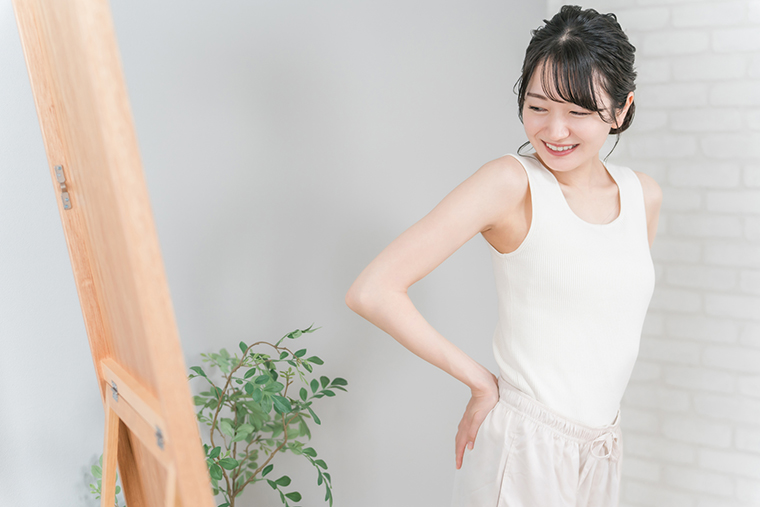 鏡で体型をチェックする女性