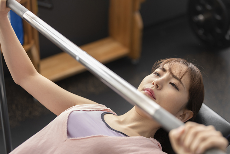 バーベルで筋トレをする女性