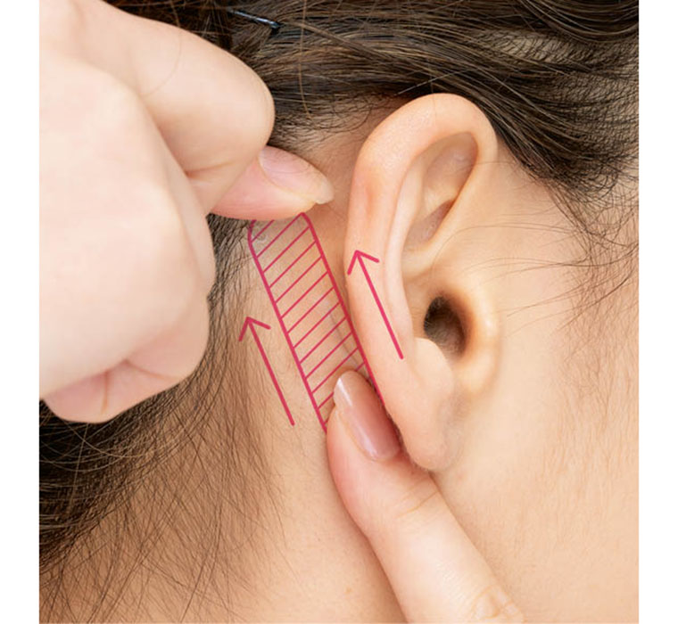 耳の裏側にテープを貼る
