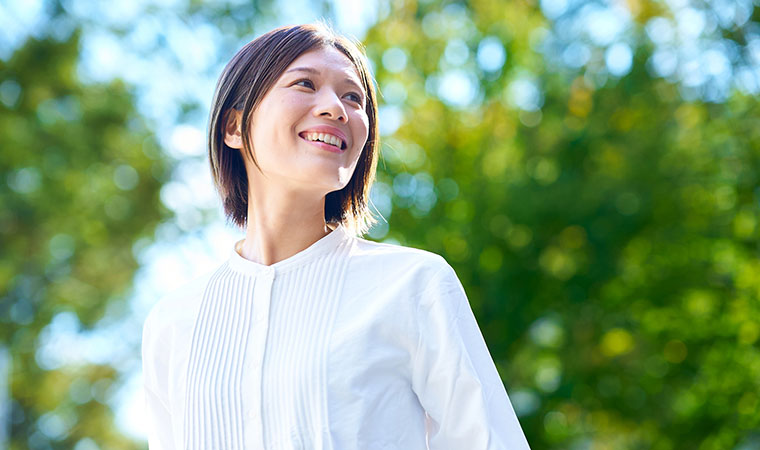 笑顔で外を歩く女性