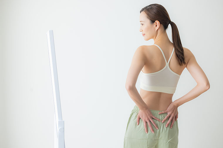 腰に手を当てる女性