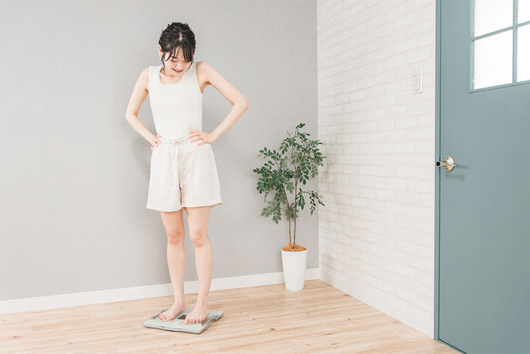 体重計にのって喜ぶ女性
