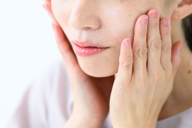 頬に手をあてる女性