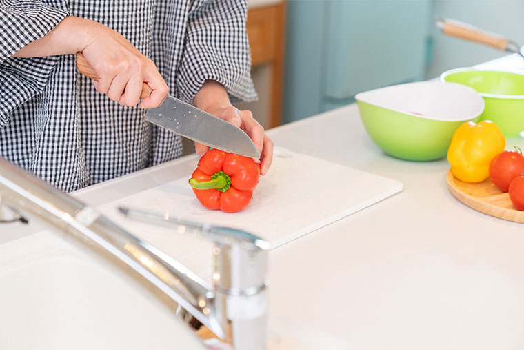 包丁で野菜を切る女性