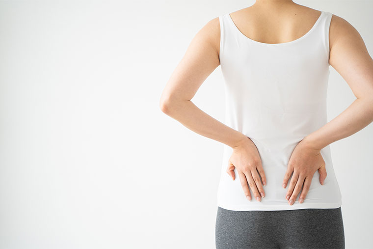 腰に手をあてる女性の後ろ姿