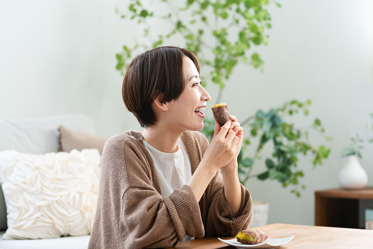 さつまいもを食べる女性