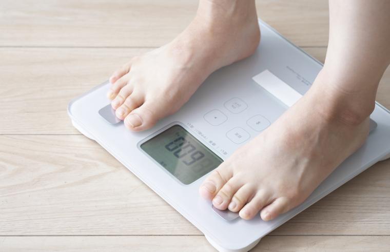 体重計に乗っている女性の足元