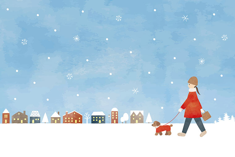 犬を連れて雪が降る街中を歩く女性のイラスト