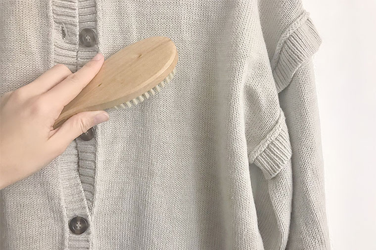 洋服にブラシをかける女性の手元