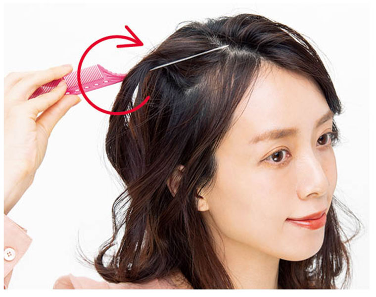 すくった髪をくしでねじる