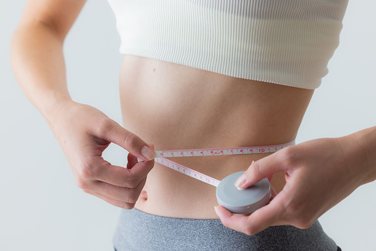 ウエストを測る女性