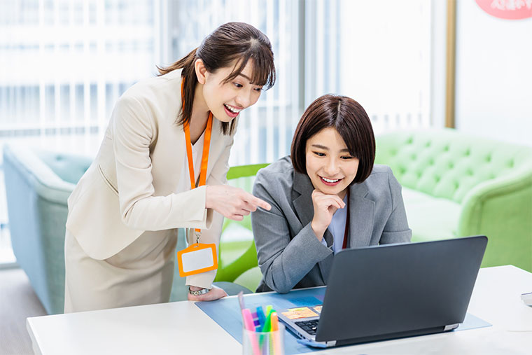 パソコンの画面を見る女性たち