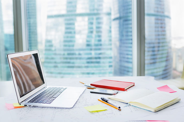 本やパソコンが置いてあるデスク