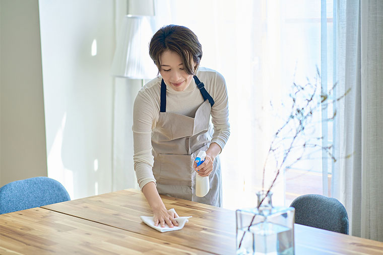 机の拭き掃除をする女性