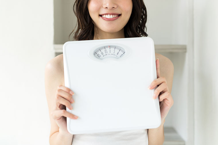体重計を持つ女性