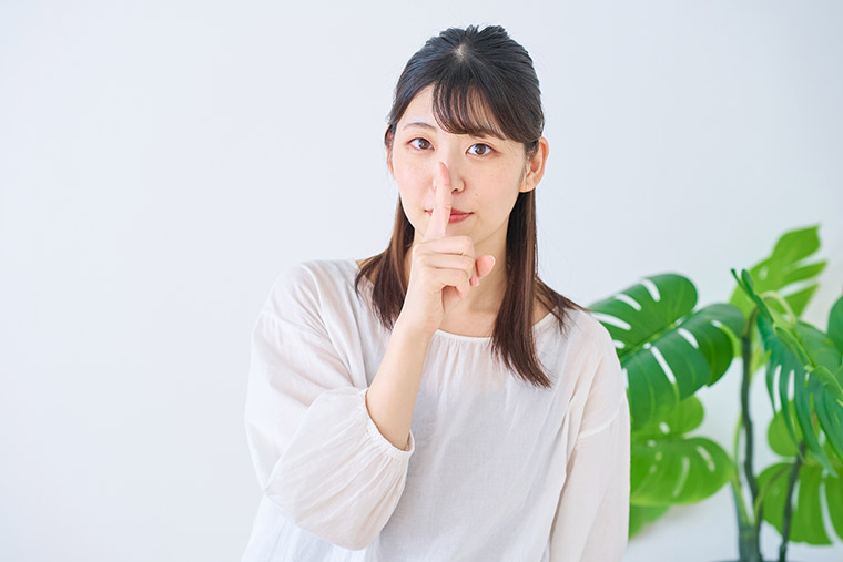 人差し指を口元にあてる女性
