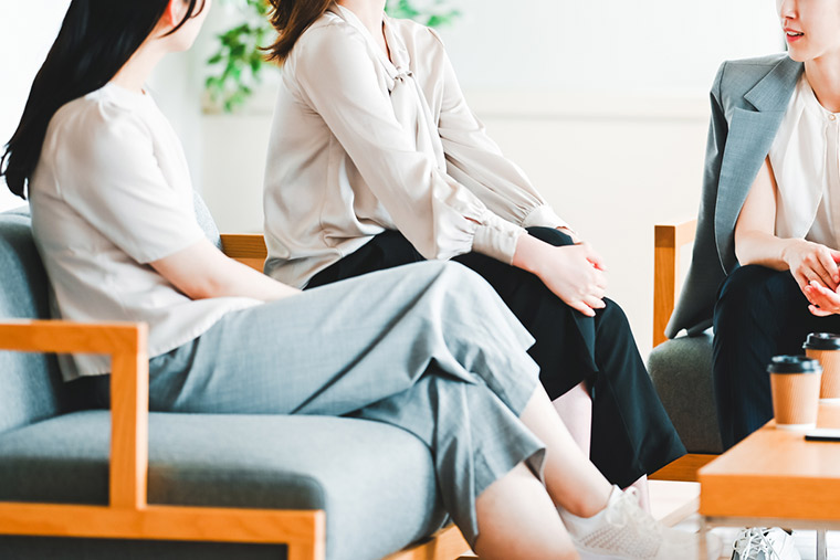 脚を組んで座る女性