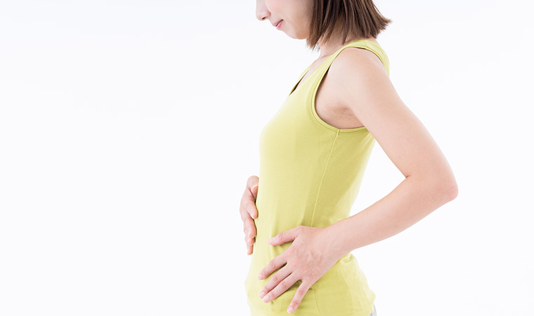 お腹に手をあてる女性